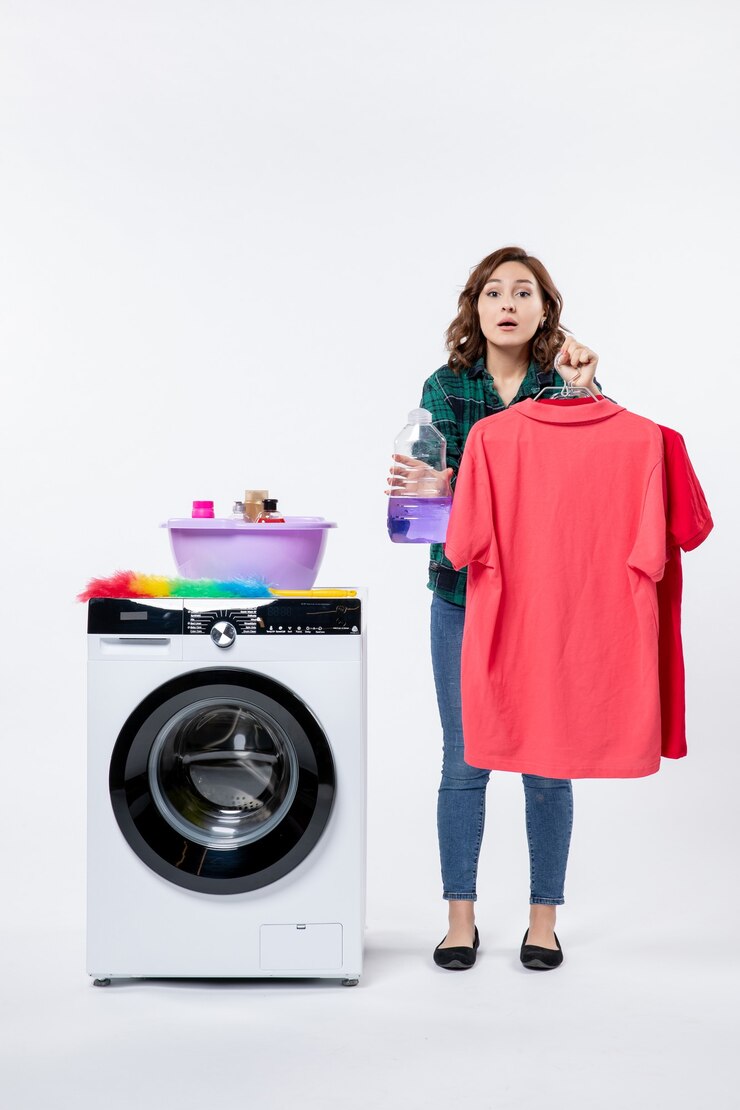 front view young female holding clean clothes liquid powder from washing machine white wall